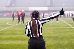 rear view of female american football referee photo