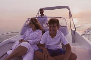 A senior couple in casual outfits with their son enjoy while riding a boat at sea at sunset. The concept of a happy family. Selective focus photo