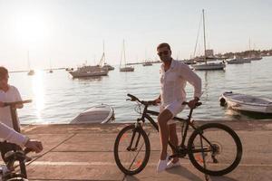 Senior couple enjoying a beautiful morning together riding a bike by the sea. Selective focus photo