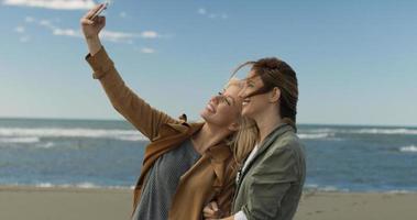 Girls having time and taking selfie on a beach photo