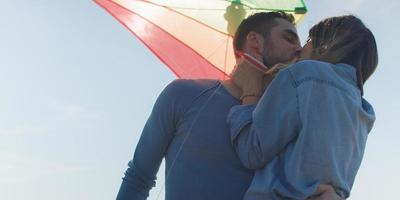 Happy couple having fun with kite on beach photo