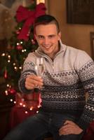 Happy young man with a glass of champagne photo