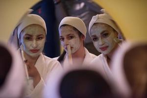 women putting face masks in the bathroom photo