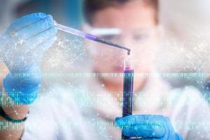 female student with protective glasses making chemistry experiment photo