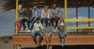 grupo de amigos divirtiéndose el día de otoño en la playa foto