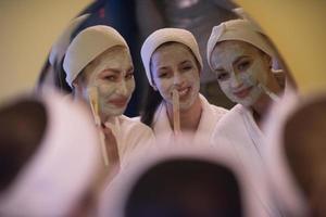 women putting face masks in the bathroom photo