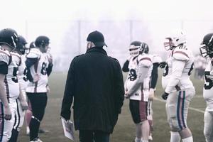 american football players discussing strategy with coach photo