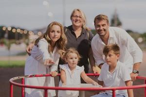 An elderly couple in casual clothes with their children and grandmother spend time together in the park on vacation. Family time. Selective focus photo