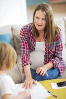 hija pintando uñas a su madre embarazada foto