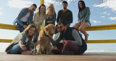 Group of friends having fun on autumn day at beach photo