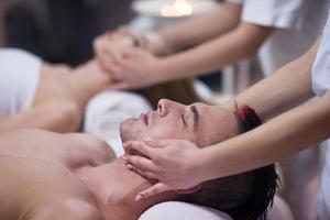 couple enjoying head massage at the spa photo