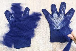 craftsman spreads second layer of fibers on glove photo