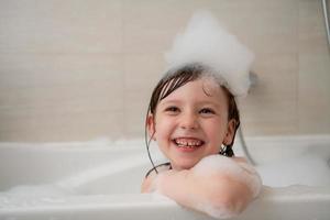 niña en el baño jugando con espuma foto