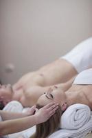 couple enjoying head massage at the spa photo