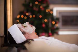 woman is getting facial clay mask at spa photo