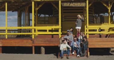 Group of friends having fun on autumn day at beach photo