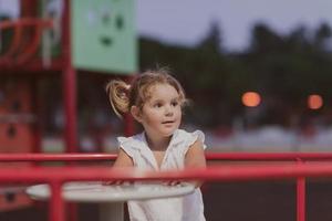 A little girl in modern summer clothes playing in the park in summer. Selective focus photo