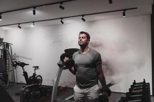 Struggling with age. Confident senior man exercising with dumbbells in health club. Selective focus photo