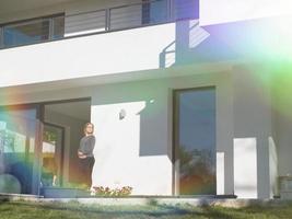 women using tablet computer in front of luxury home villa photo