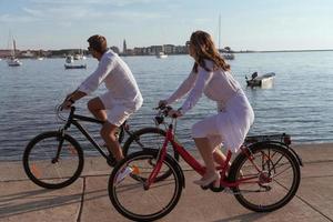 Senior couple enjoying a beautiful morning together riding a bike by the sea. Selective focus photo