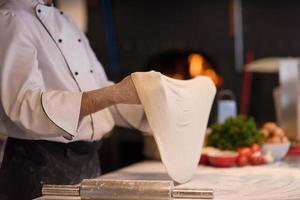 chef throwing up pizza dough photo