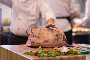 chef cutting big piece of beef photo