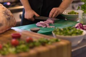 Chef  hands cutting the onion with knife photo