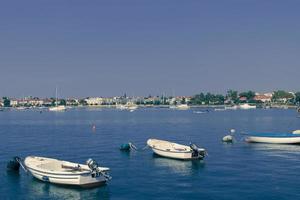 A photograph of a ship and a luxury yacht anchored in port. Beautiful photo of a Mediterranean port