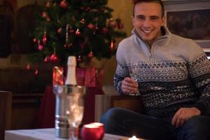 Happy young man with a glass of champagne photo