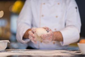 chef hands preparing dough for pizza photo