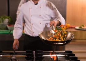 chef flipping vegetables in wok photo