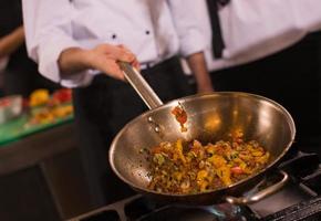 chef flipping vegetables in wok photo