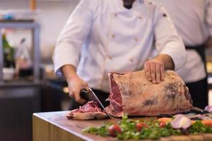 chef cortando un gran trozo de carne foto