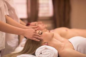 couple enjoying head massage at the spa photo