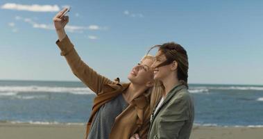 chicas teniendo tiempo y tomando selfie en una playa foto