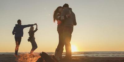 Friends having fun at beach on autumn day photo