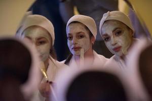 women putting face masks in the bathroom photo