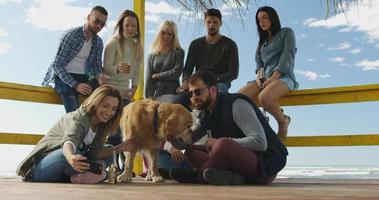 Group of friends having fun on autumn day at beach photo