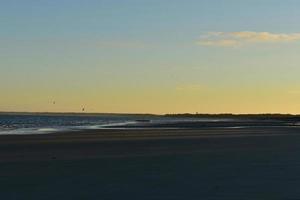 hermosa puesta de sol en Cape Cod con una casa de luz en la distancia foto