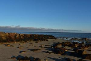 Bright sunny day with a large jetty on a beach photo