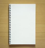 blank spiral notebook on wood background photo