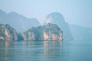 island and rocks in thailand near the blue sea in fog photo