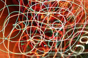 abstract color swirl garland lights. Blurred glowing on dark background photo