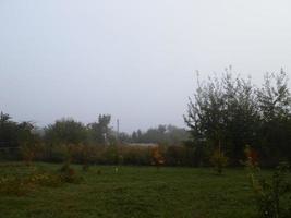 Autumn morning mist in the village photo