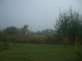 Autumn morning mist in the village photo