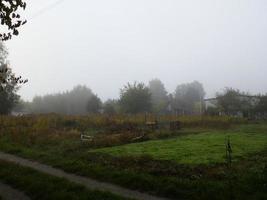 Autumn morning mist in the village photo