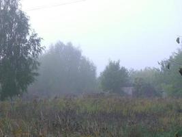 Autumn morning mist in the village photo