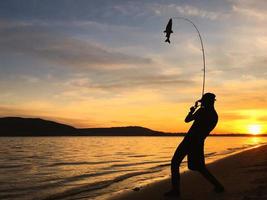 joven pescando al atardecer foto