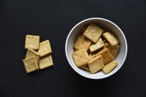 Delicious peppery cookies in a white plate on a black background. photo