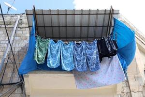 Washed clothes and linen dries on the balcony. photo